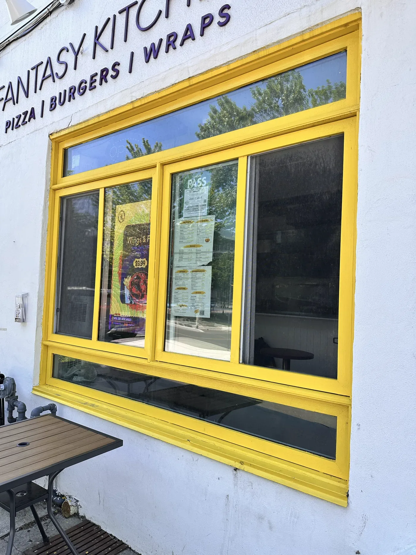 The yellow shopfront window on Harbord Street, with the menu and the $9.99 combo poster inside